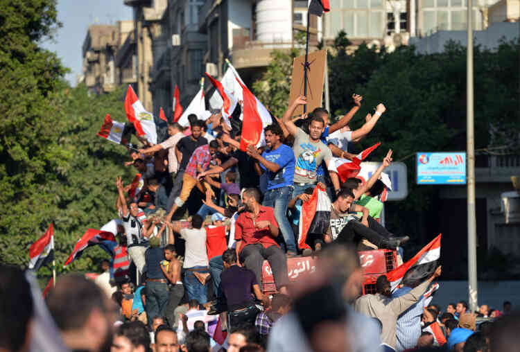 Egyptians holding up their national flag celebrate on June 24, 2012, in Cairo’s Tahrir Square, the victory of Muslim Brotherhood member Mohamed Morsi who was declared the first president of Egypt since a popular uprising ousted Hosni Mubarak, capping a tumultuous and divisive military-led transition.  AFP PHOTO / KHALED DESOUKI