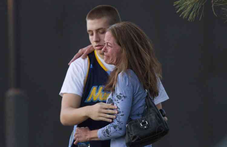 Eyewitness Jacob Stevens, 18, hugs his mother Tammi Stevens after being interview by police outside Gateway High School where witnesses were brought for questioning Friday, July 20, 2012 in Aurora, Colo.  A gunman wearing a gas mask set off an unknown gas and fired into the crowded movie theater killing 12 people and injuring at least 50 others, authorities said. (AP Photo/Barry Gutierrez)