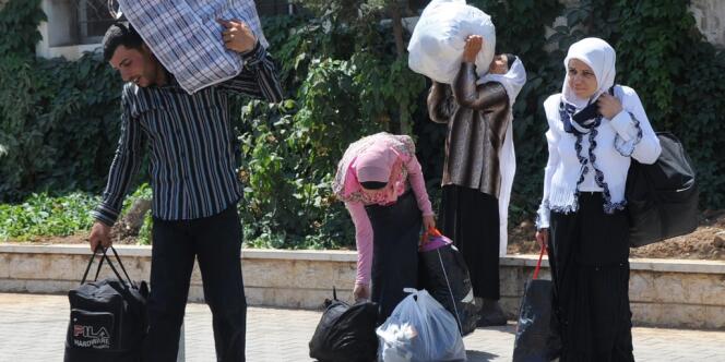 Des Syriens fuient les violences à Damas en passant la frontière à Masnaa, en direction du Liban.