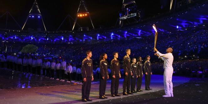 Le rameur Steve Redgrave, Britannique le plus médaillé de l'histoire, transmet la flamme à sept jeunes athlètes.