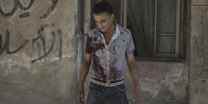 Un habitant du quartier de Salaheddine, à Alep, vient de secourir un ami blessé, le 8 août.