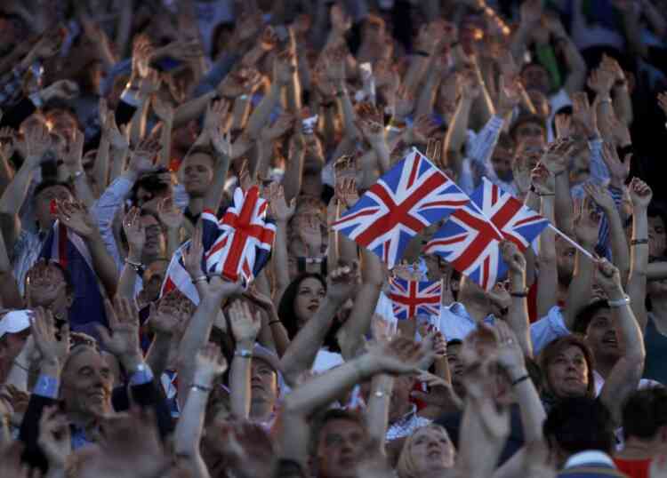 Guests stand and wave Britain's flag during the closing ceremony of the London 2012 Olympic Games at the Olympic Stadium August 12, 2012.          REUTERS/Gary Hershorn (BRITAIN  - Tags: SPORT OLYMPICS)