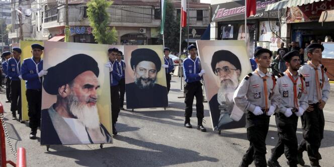 Des partisans du Hezbollah lors d'une manifestation à Beyrouth, le 17 août, portent des portraits du Guide suprême iranien, l'ayatollah Ali Khamenei et de son prédecesseur Khomeini, ainsi que celui de l'imam disparu Moussa Al-Sadr (au centre).