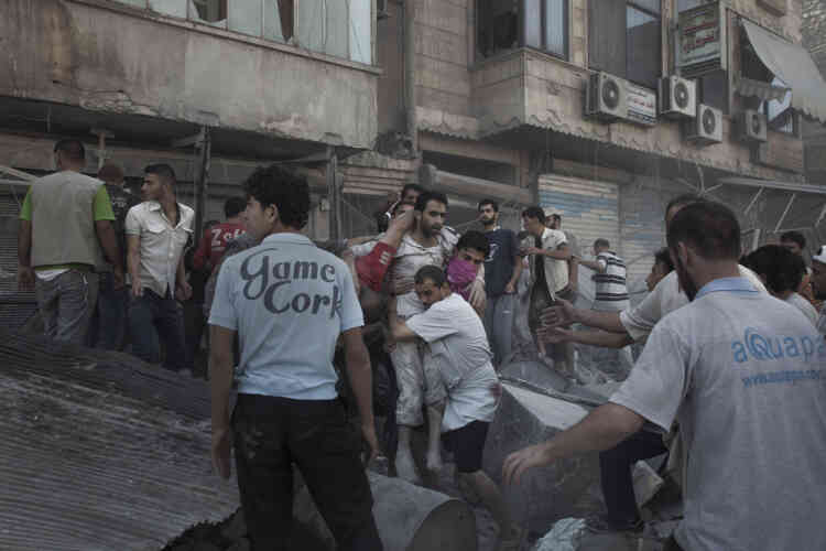 Tarik Al Bab, Aleppo, 09/08/2012. A Syrian Army Plane dropped a bomb on a residential building of the populated square in Central Aleppo. Douzen of bodies, killed and wounded are carried to the Al Shifa hospital while citizens continue to look for bodies under the rubles. photo Laurent Van der Stockt for Le Monde