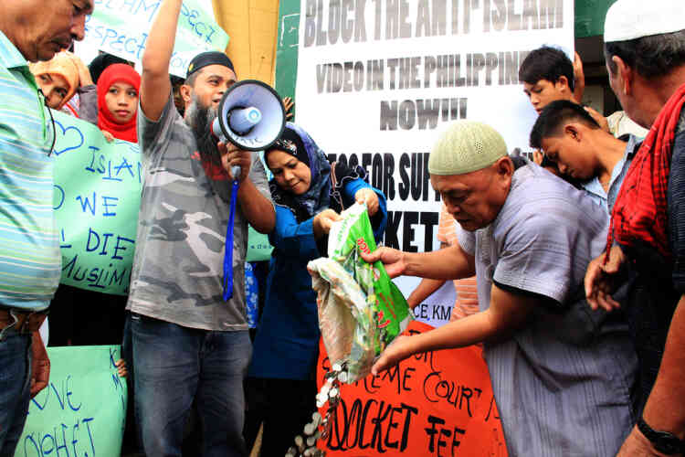 Philippine Muslims collect money to be used to file law suits against showing the anti-Islam film during a gathering in Marawi City, Lanao del sur, in southern island of Mindanao on September 21, 2012. The low-budget movie, entitled "Innocence of Muslims", has sparked fury across the Islamic world for mocking the Prophet Mohammed, and for portraying Muslims as immoral and gratuitously violent. Meanwhile in Manila, a law professor of the state university has said he will show the controversial to his class later in defiance of university order banning the screening. AFP PHOTO/Richele Umel