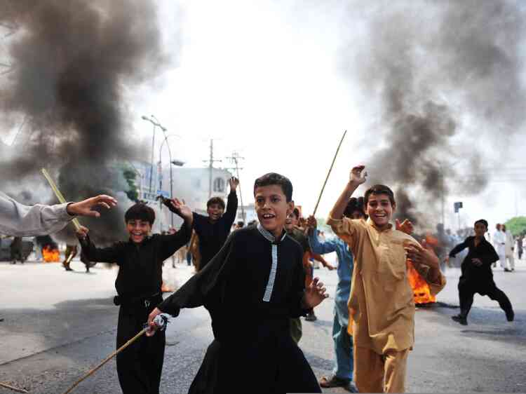 Pakistani demonstrators react beside burning tyres as they block a main highway during a protest against an anti-Islam film in Rawalpindi on September 21, 2012.Thousands of Pakistanis are expected to take to the streets to demonstrate against a US-made anti-Islam film after the government called an impromptu public holiday to let people protest. The crudely made film, produced by US-based extremist Christians, has triggered protests in at least 20 countries since excerpts were posted online, and more than 30 people have been killed in violence linked to the film. AFP PHOTO / AAMIR QURESHI