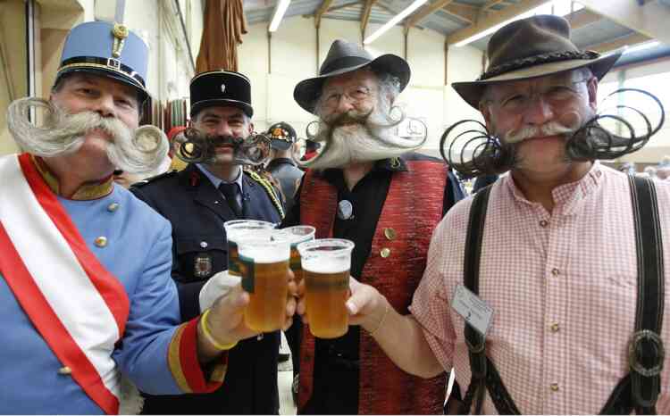 Participants have a beer as they take part in the 2012 European Beard and Moustache Championships in Wittersdorf near Mulhouse, Eastern France, September 22, 2012. More than a hundred participants competed in the first European Beard and Moustache Championships organized in France. REUTERS/Vincent Kessler (FRANCE - Tags: SOCIETY)