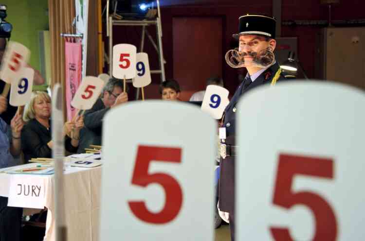 Jury members vote as a competitor stands on stage during the first edition of the European Beard and Moustache championships on September 22, 2012 in Wittersdorf, eastern France.  AFP PHOTO / SEBASTIEN BOZON
