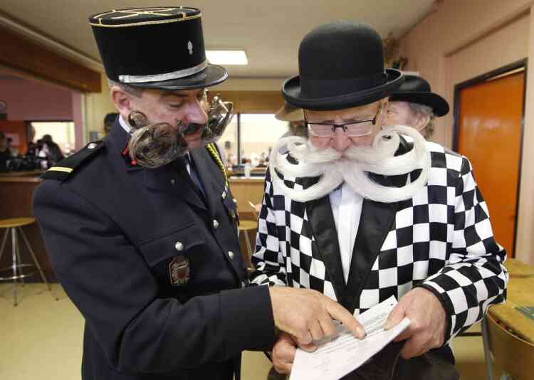 Participants read documents as they take part in the 2012 European Beard and Moustache Championships in Wittersdorf near Mulhouse, Eastern France, September 22, 2012. More than a hundred participants competed in the first European Beard and Moustache Championships organized in France. REUTERS/Vincent Kessler (FRANCE - Tags: SOCIETY)