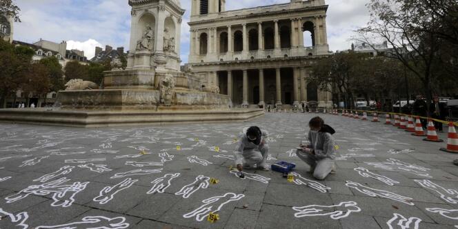 Des membres de l'association Action contre la faim dessinent des silhouettes de scènes de crime pour symboliser les personnes mortes de faim dans le monde, le 15 octobre à Paris. 