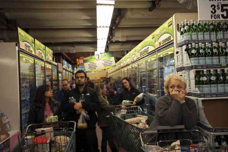 Customers wait in line to buy groceries at the Fairway super market in New York, October 28, 2012. Hurricane Sandy could be the biggest storm to hit the United States mainland when it comes ashore on Monday night, bringing strong winds and dangerous flooding to the East Coast from the mid-Atlantic states to New England, forecasters said on Sunday. REUTERS/Keith Bedford (UNITED STATES - Tags: SOCIETY ENVIRONMENT)