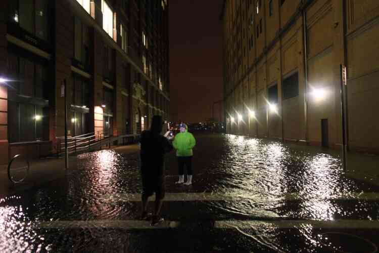 NEW YORK, NY - OCTOBER 29: People take photographs in flood water in the Meatpacking District on October 29, 2012 in Manhattan, New York. Hurricane Sandy, which threatens 50 million people in the Mid-Atlantic area of the United States, is expected to bring days of rain, high winds and possibly heavy snow. New York Governor Andrew Cuomo announced the closure of all New York City bus, subway and commuter rail services as of Sunday evening.   Allison Joyce/Getty Images/AFP== FOR NEWSPAPERS, INTERNET, TELCOS & TELEVISION USE ONLY ==