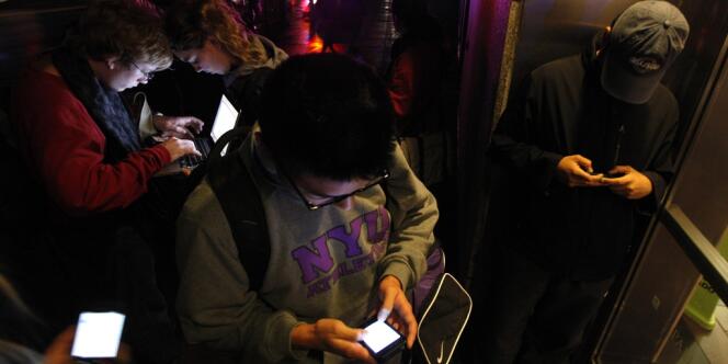 Des New-Yorkais se massent devant un bâtiment ayant encore un accès Wifi, le 30 octobre.