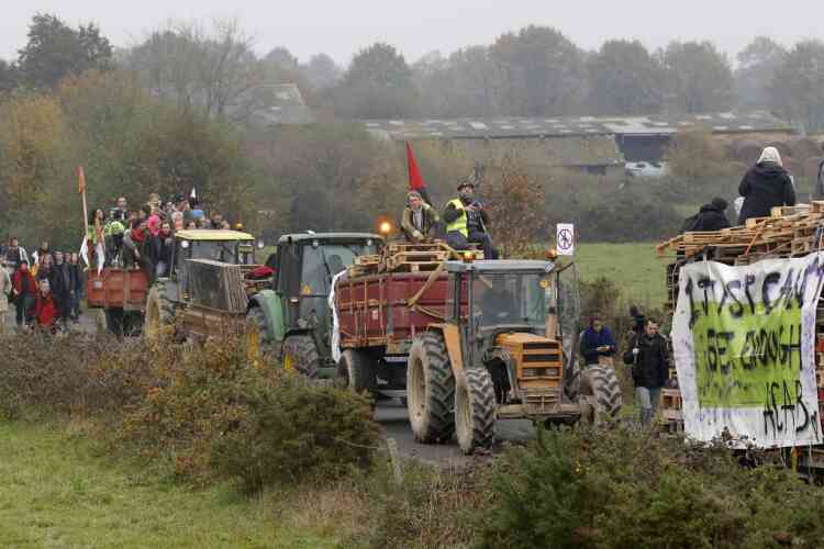 People ride on tractors as they take part in a demonstration against plans to construct a new airport in Notre-Dame-des-Landes, western France, November 17, 2012. The new airport, some 30kms (19 miles) from Nantes, is scheduled to be constructed for 2017.  REUTERS/Stephane Mahe (FRANCE  - Tags: TRANSPORT CIVIL UNREST POLITICS)