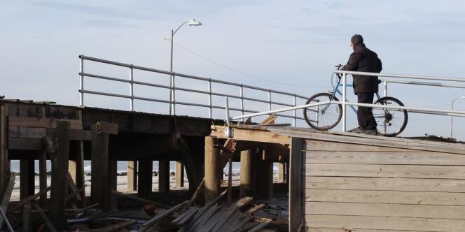 Un cycliste constate les dégats commis par le passage de l'ouragan Sandy, à Long Beach. La tempête historique qui s'est abattue sur la côte Est des Etats-Unis le 29 octobre a fait au moins 132 morts dont 43 dans la ville de New York, selon un dernier bilan.