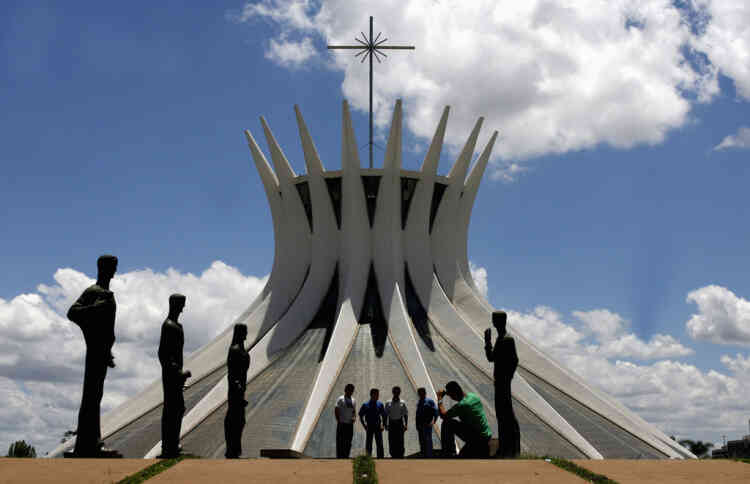 Tourists take pictures in front of the Metropolitan Cathedral designed by architect Oscar Niemeyer in Brasilia, in this December 12, 2007 file photo. Niemeyer, a towering patriarch of modern architecture who shaped the look of modern Brazil and whose inventive, curved designs left their mark on cities worldwide, died late on December 5, 2012. He was 104. Niemeyer had been battling kidney ailments and pneumonia for nearly a month in a Rio de Janeiro hospital. His death was confirmed by a hospital spokesperson. REUTERS/Jamil Bittar/Files (BRAZIL - Tags: OBITUARY SOCIETY)