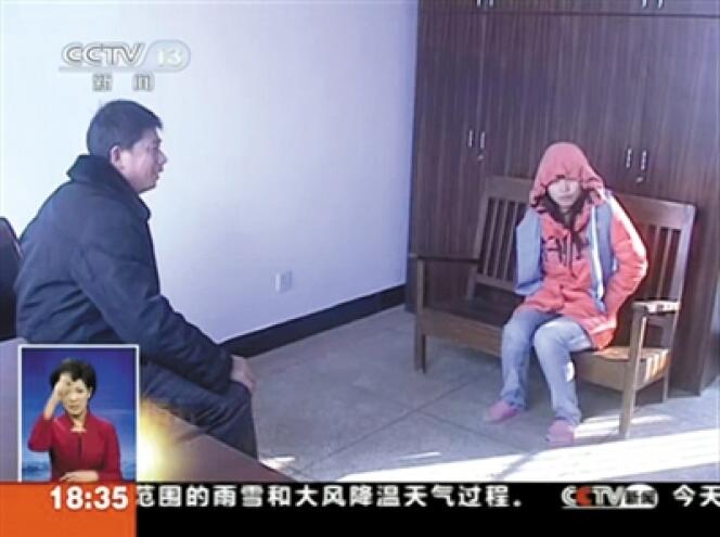 Image de la télévision chinoise montrant une adepte de la secte interrogée par un policier