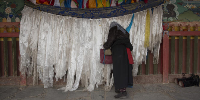 Un Tibétain fait des offrandes au monastère de Labrang.