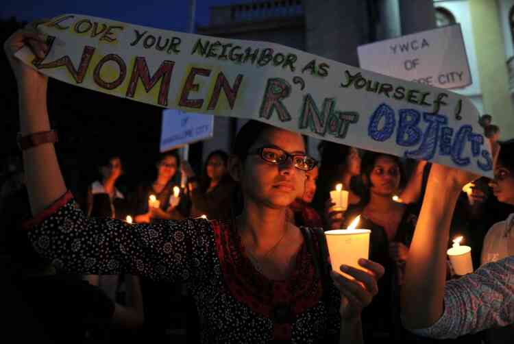 Indian activists belonging to various rights organisations hold placards and candles while they stage a demonstration in Bangalore on December 21, 2012, condemning the recent gang rape in New Delhi. India's government, facing swelling protests over the gang-rape of a female student on a bus, has vowed to press for life sentences for her six attackers and promised stricter policing. AFP PHOTO/Manjunath KIRAN