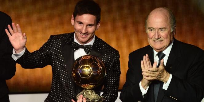 Lionel Messi, habillé pour l'occasion, reçoit son 4e Ballon d'or consécutif des mains du président de la FIFA, Sepp Blatter.
