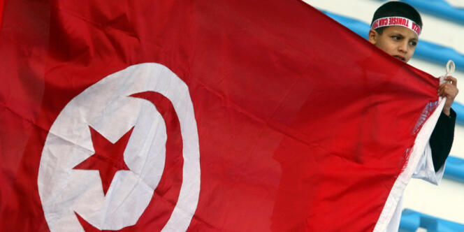 Un jeune garçon brandit un drapeau tunisien lors d'un match à Sfax, en janvier 2004.