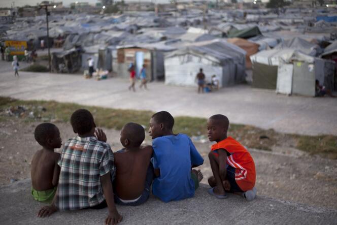 Des enfants haïtiens observent le camp de tentes Jean-Marie Vincent, à Port-au-Prince, le 9 janvier.