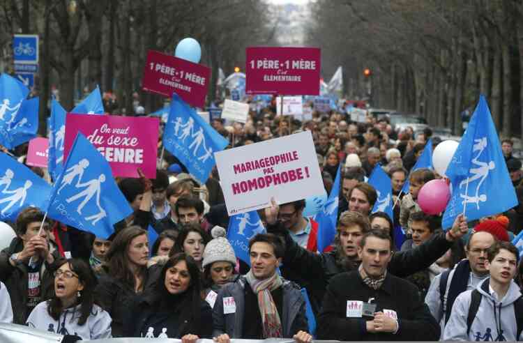 People demonstrate with red placards reading 'One father, one mother, it's obvious" and in Paris, Sunday, Jan. 13, 2013. Many thousands of protesters are mobilizing against the French president's plan to legalize gay marriage, streaming into Paris by bus, car and specially reserved high-speed train. Placard at center reads: Pro-marriage, not anti gay. (AP Photo/Michel Euler)