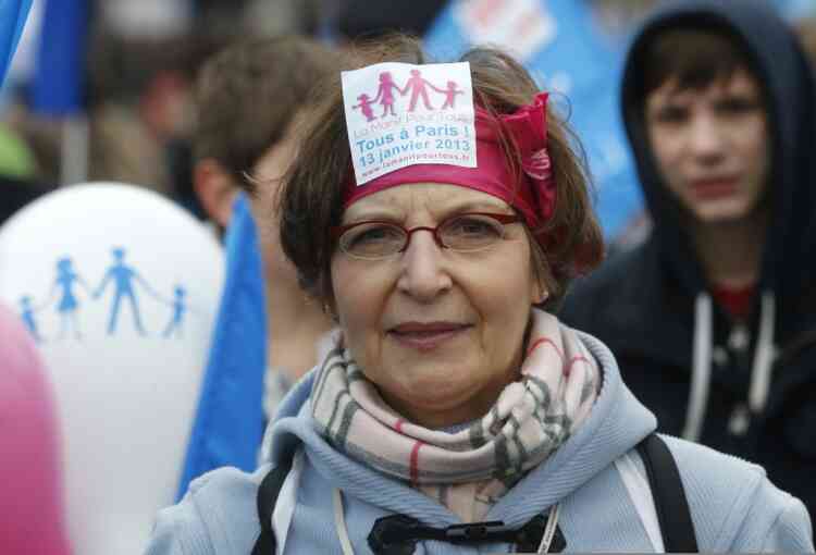 A woman demonstrates with a sticker reading 'Everybody in Paris' on Jan. 13' In Paris, Sunday, Jan. 13, 2013. Many thousands of protesters are mobilizing against the French president's plan to legalize gay marriage, streaming into Paris by bus, car and specially reserved high-speed train. (AP Photo/Michel Euler)
