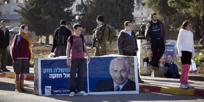 Des colons israéliens devant une affiche électorale de Benyamin Nétanyahou, à Gush Etzion, en Cisjordanie, le 15 janvier.