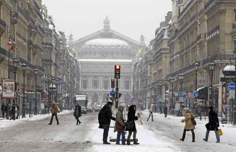 Tourists and Parisians walk on the Opera Avenue after heavy snow fall,  in Paris, Sunday, Jan. 20, 2013. (AP Photo/Remy de la Mauviniere)