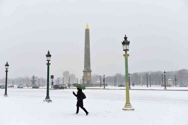 A woman walks on the snow covered Place de la Concorde  on January 20, 2013 in Paris, after heavt snow falls over the French capital. AFP PHOTO / MIGUEL MEDINA