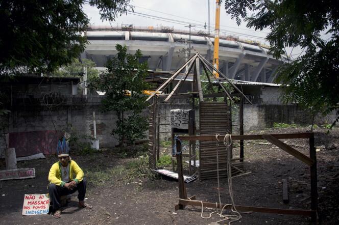 Un Indien est assis, le 15 janvier, dans l'enceinte de ce qui était la Maison des Indiens de Rio. En arrière-plan, le stade Maracana.