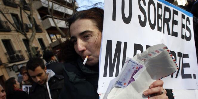 Une jeune Espagnole défile une enveloppe pleine d'argent à la main pour protester contre la corruption. 