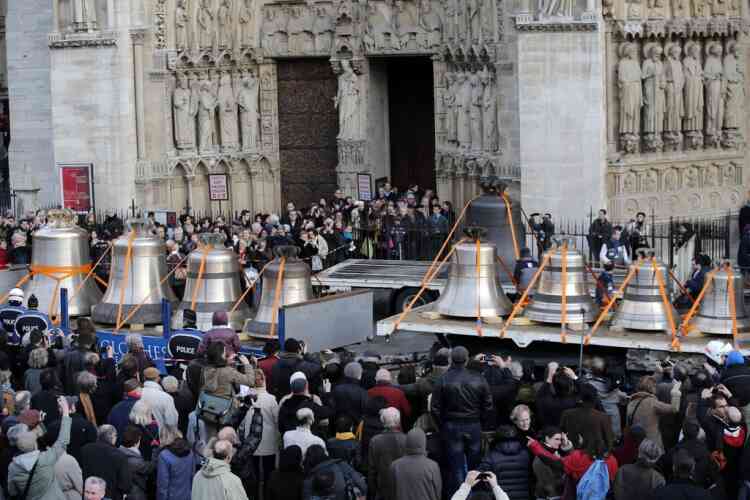 Visitors gather around new bells in front of the Notre Dame cathedral, in Paris, Thursday, Jan. 31, 2013. Nine bronze bells have made their way on flatbed trucks from a Normandy foundry to what is hoped will be their home for centuries to come, Notre Dame Cathedral, helping the medieval edifice to rediscover its historical harmony. (AP Photo/Christophe Ena)