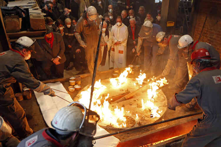 Employees ignite escaping gases after the molten metal arrived inside the mould for the bronze bell 'Anne-Genevieve' at the French bell foundry Cornille Havard in Villedieu-les-Poeles in Normandy December 14, 2012. The foundry, using medieval methods, was chosen to design and cast the eight replacement bronze bells for the north tower of Notre-Dame de Paris Cathedral, set to be finished in time to ring in the 850th anniversary of the cathedral next year. The new bells, which will be displayed at Notre Dame in February, will have the same weight and diameter as the ones from the 18th-century which were melted down and turned into cannons during the French Revolution, and are designed to produce the same sound. The bell 'Anne-Genevieve' is the final bell to be cast for the Notre-Dame de Paris Cathedral.    REUTERS/Charles Platiau  (FRANCE - Tags: SOCIETY RELIGION TPX IMAGES OF THE DAY) - RTR3BKSQ