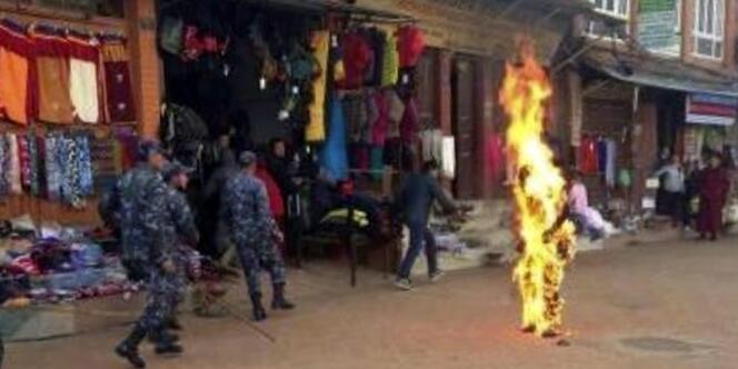 Des policiers népalais se précipitent pour secourir le Tibétain qui s'est immolé à Katmandou.