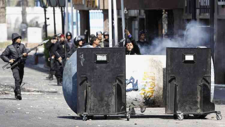 A riot police officer releases tear gas at protesters opposing Egyptian President Mohamed Mursi during clashes in front of Security Directorate in Port Said city, 170 km (105 miles) northeast of Cairo March 5, 2013. Police shot into the air and fired tear gas during clashes with hundreds of protesters in Egypt's Port Said on Tuesday, the third day of violent protests in the port city, a Reuters witness said.   REUTERS/Amr Abdallah Dalsh (EGYPT - Tags: POLITICS CIVIL UNREST)