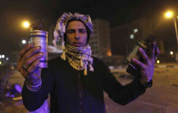 A protester, who opposes Egyptian President Mohamed Mursi, shows empty teargas canisters during clashes with riot police in front of Security Directorate of Port Said after protesters started to set fire to it in Port Said city, 170 km (106 miles) northeast of Cairo March 4, 2013. Protesters hurled petrol bombs and stones at police officers who responded by firing teargas in Egypt's Port Said on Monday, a day after deadly demonstrations in the Suez Canal city. REUTERS/Amr Abdallah Dalsh (EGYPT - Tags: POLITICS CIVIL UNREST)