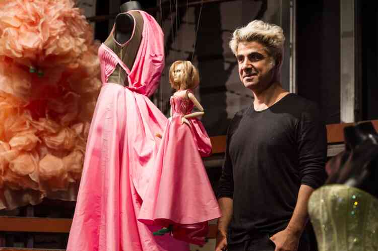 Designer Fause Haten poses next to a marionette during the Sao Paulo Fashion Week 2013 Summer collections, in Sao Paulo, Brazil, on March 20, 2013. Real size collections are also showed after the show. AFP PHOTO / Yasuyoshi CHIBA