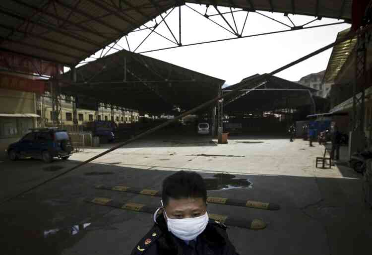 In this Saturday, April 6, 2013 photo, a security guard wearing a face mask stands guard at a poultry market which has been closed by local government officials in Nanjing in east China's Jiangsu province. Shanghai has reported two more cases of human infection of a new strain of bird flu, raising the number of cases in eastern China to 18. Six of the people who contracted the virus have died. Health officials believe people are contracting the H7N9 virus through direct contact with infected fowl and say there's no evidence the virus is spreading easily between people. (AP Photo) CHINA OUT