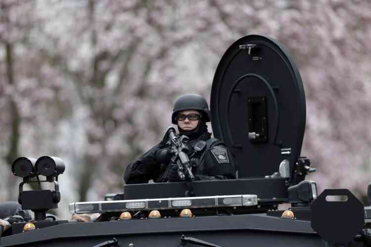 A police officer in tactical gear conducts a search for a suspect in the Boston Marathon bombings, Friday, April 19, 2013, in Watertown, Mass. The bombs that blew up seconds apart near the finish line of the Boston Marathon left the streets spattered with blood and glass, and gaping questions of who chose to attack and why. (AP Photo/Matt Rourke)