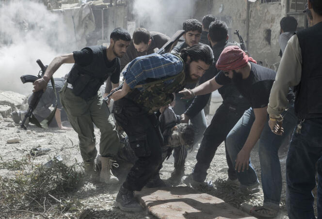 Un groupe de rebelles évacuent le corps d'un combattant tué par un tireur embusqué.