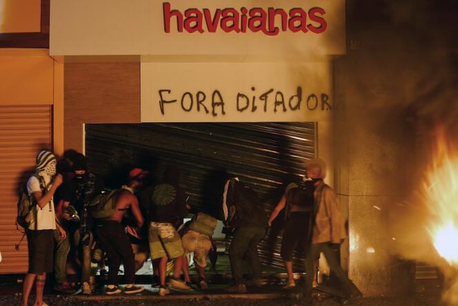 Des manifestants vandalisent un magasin de sandales, à Rio de Janeiro, le 17 juin.
