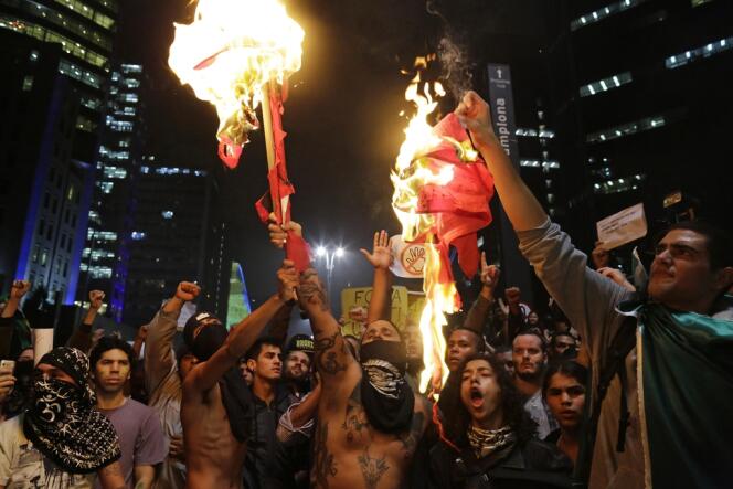 Des manifestants brûlent le drapeau du Parti des travailleurs, sur l'avenue Paulista, à Sao Paulo, le 20 juin.
