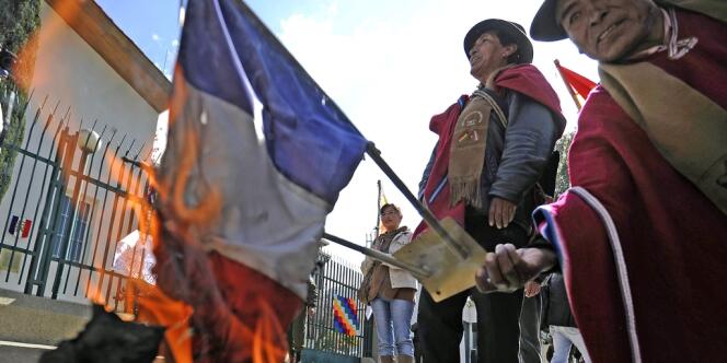 Des manifestants brûlent un drapeau tricolore devant l'ambassade de France à La Paz.