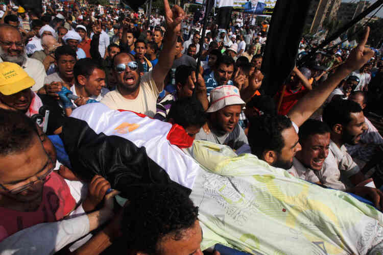 ATTENTION EDITORS - VISUAL COVERAGE OF SCENES OF INJURY OR DEATHSupporters of Egypt's deposed President Mohamed Mursi carry the body of a fellow supporter killed by violence outside the Republican Guard headquarters in Cairo July 8, 2013. The death toll in violence on Monday at the Cairo headquarters of the Republican Guard rose to 42, Egyptian state television said, after the Muslim Brotherhood accused the security forces of attacking protesters there.   REUTERS/Khaled Abdullah (EGYPT - Tags: POLITICS CIVIL UNREST) TEMPLATE OUT