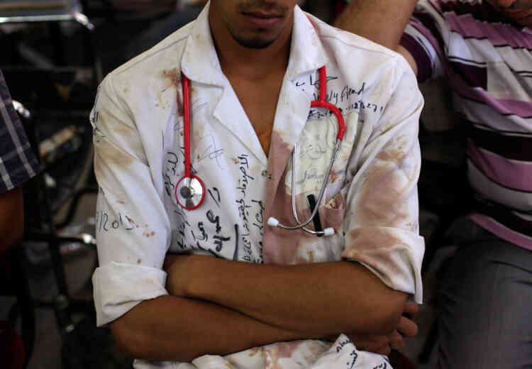 An Egyptian medic supporter of  ousted President Mohammed Morsi, sits at a field hospital in Nassr City in Cairo, Egypt, Monday, July 8, 2013. Egyptian soldiers and police opened fire on supporters of the ousted president early Monday in violence that left dozens of people killed, including one officer, outside a military building in Cairo where demonstrators had been holding a sit-in, government officials and witnesses said. (AP Photo/Khalil Hamra)