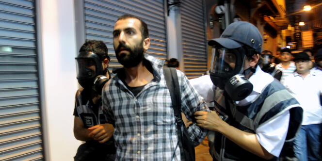Des policiers anti-émeute turcs arrêtent un manifestant lors d'affrontements avec la police sur la place Taksim à Istanbul le 8 Juillet 2013. La police anti-émeute turque a tiré des balles en caoutchouc, des gaz lacrymogènes et des canons à eau pour empêcher les manifestants de pénétrer dans un petit parc d'Istanbul, la ville natale de l'agitation meurtrière qui a ravagé le pays en juin. 