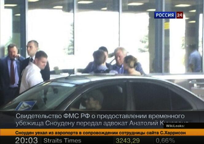 Image de la chaîne de télévision Russia24 montrant Edward Snowden (de dos au centre) discuter avec son avocat à l’aéroport de Moscou, jeudi 1er août.
