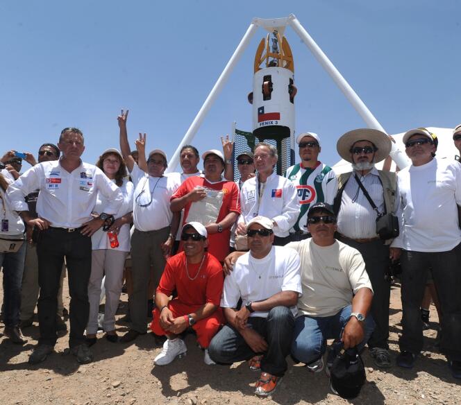 Une partie des mineurs chiliens coincés sous terre posent, début 2011, devant la capsule qui a permis de les extraire du fond de la mine, en 2010.